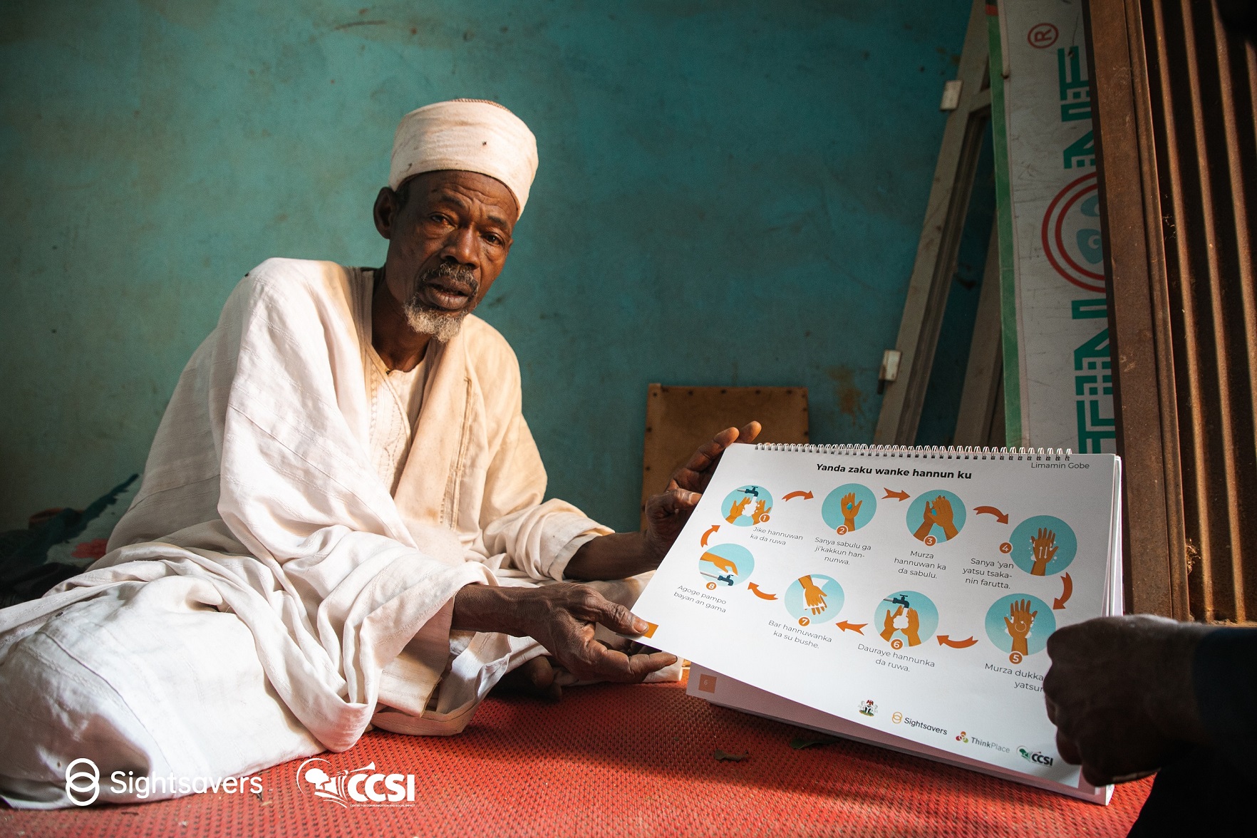 Imam Faruku of Gande Community showcasing his instructional material.