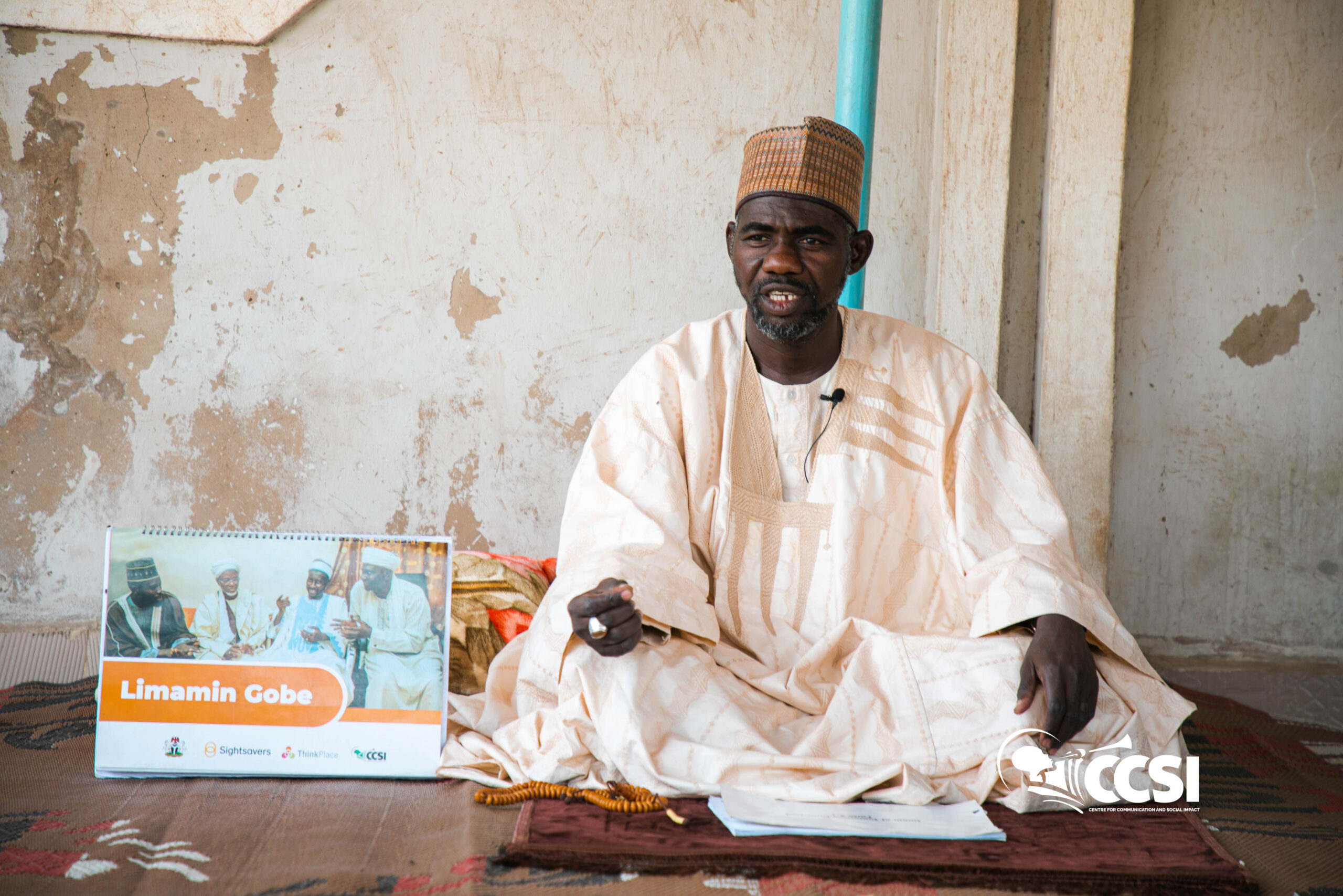 Imam Ahmed Jinjiri posing with his instructional material on trachoma